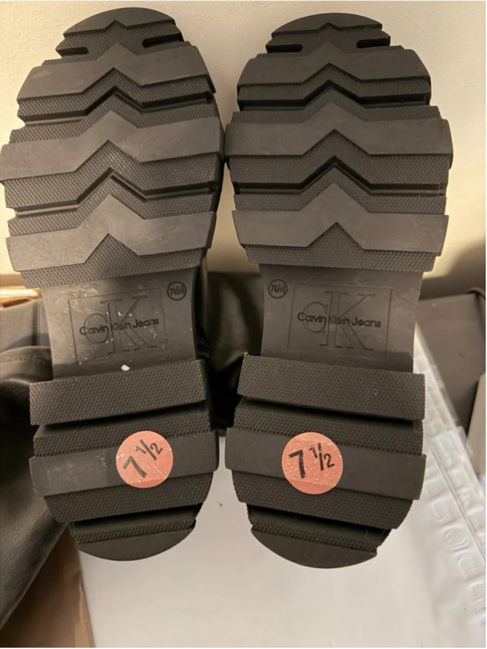 Calvin Klein black chunky platform boots featuring a thick, ridged lug sole.